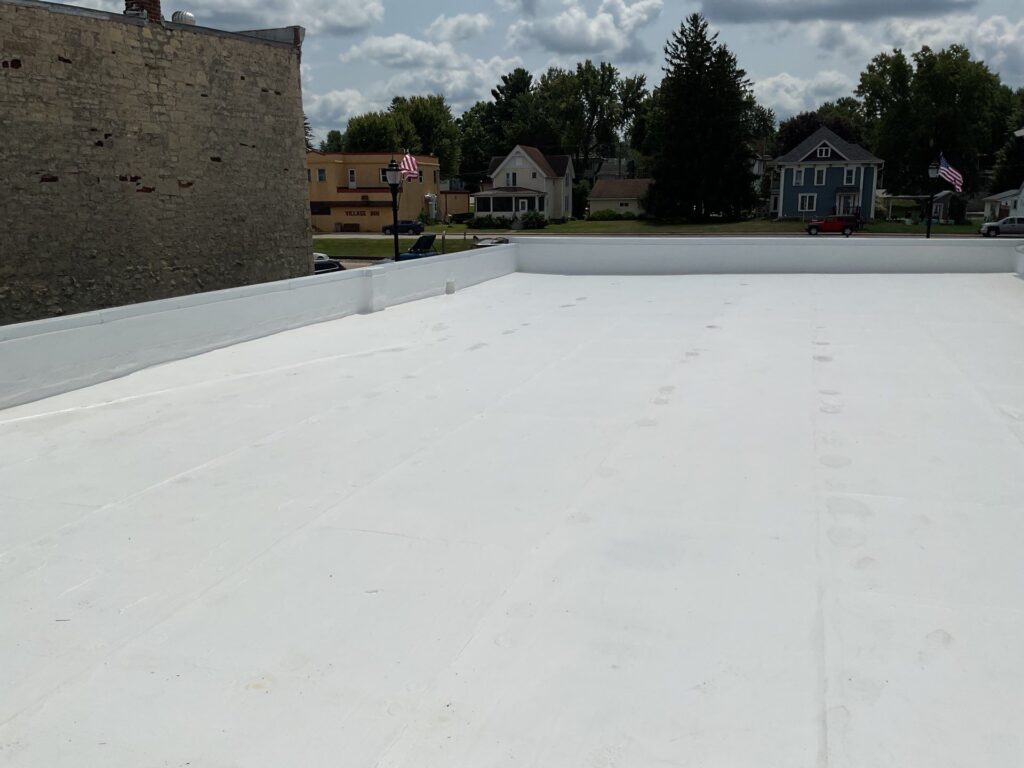 Newly installed white flat roof in small town setting