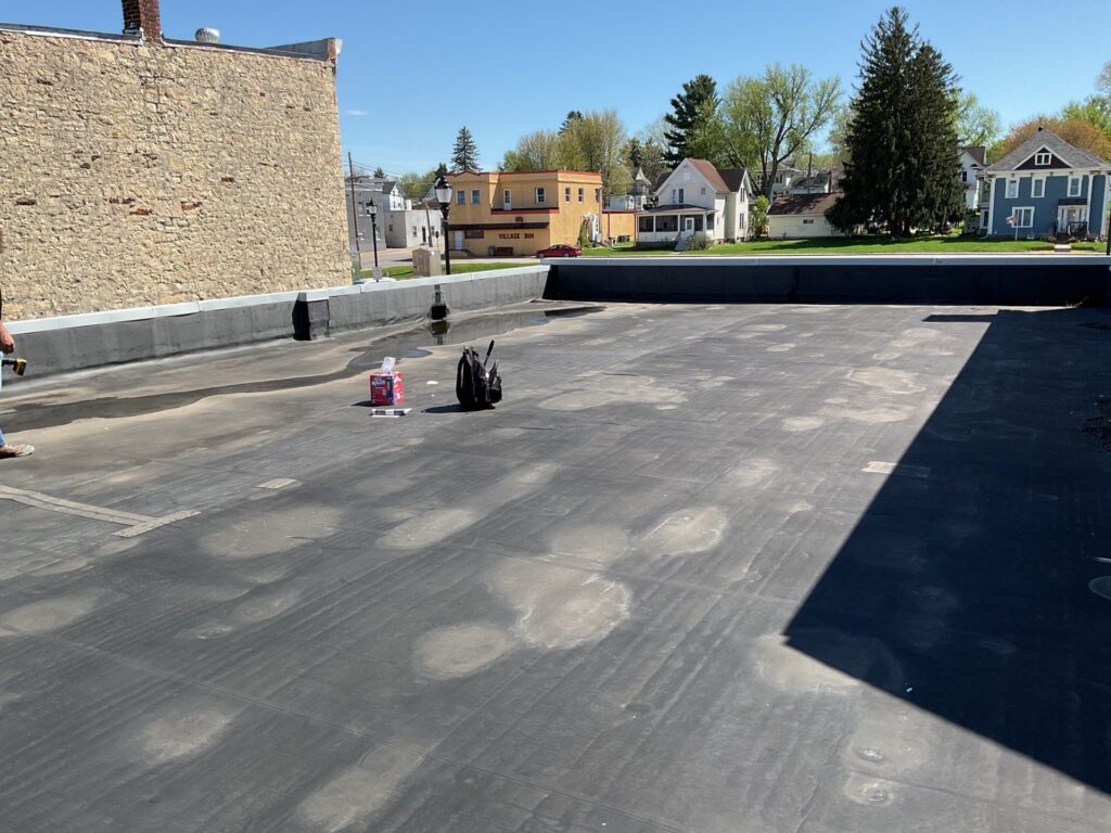 Flat commercial rooftop with tools overlooking small town